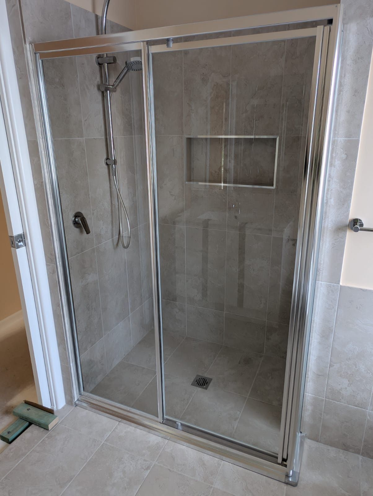 Framed sliding shower screen in polished silver aluminium