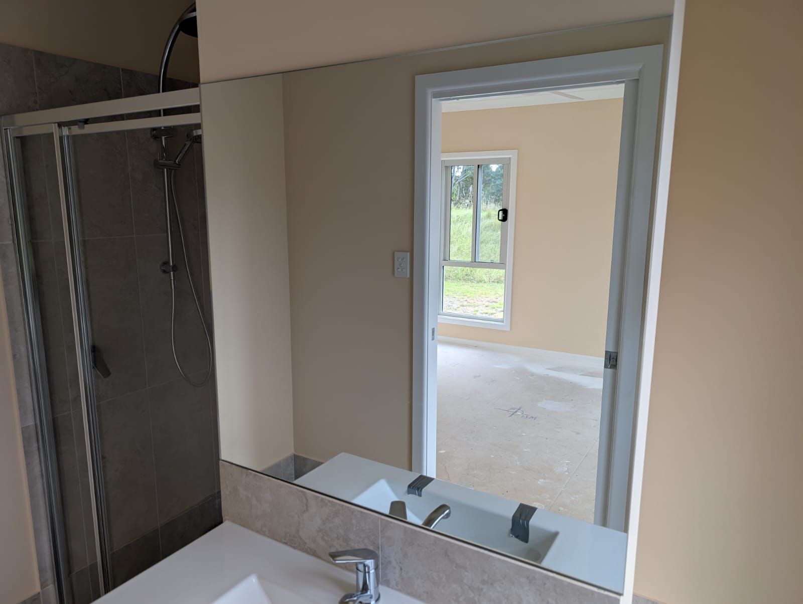 Wide frameless vanity mirror in an ensuite