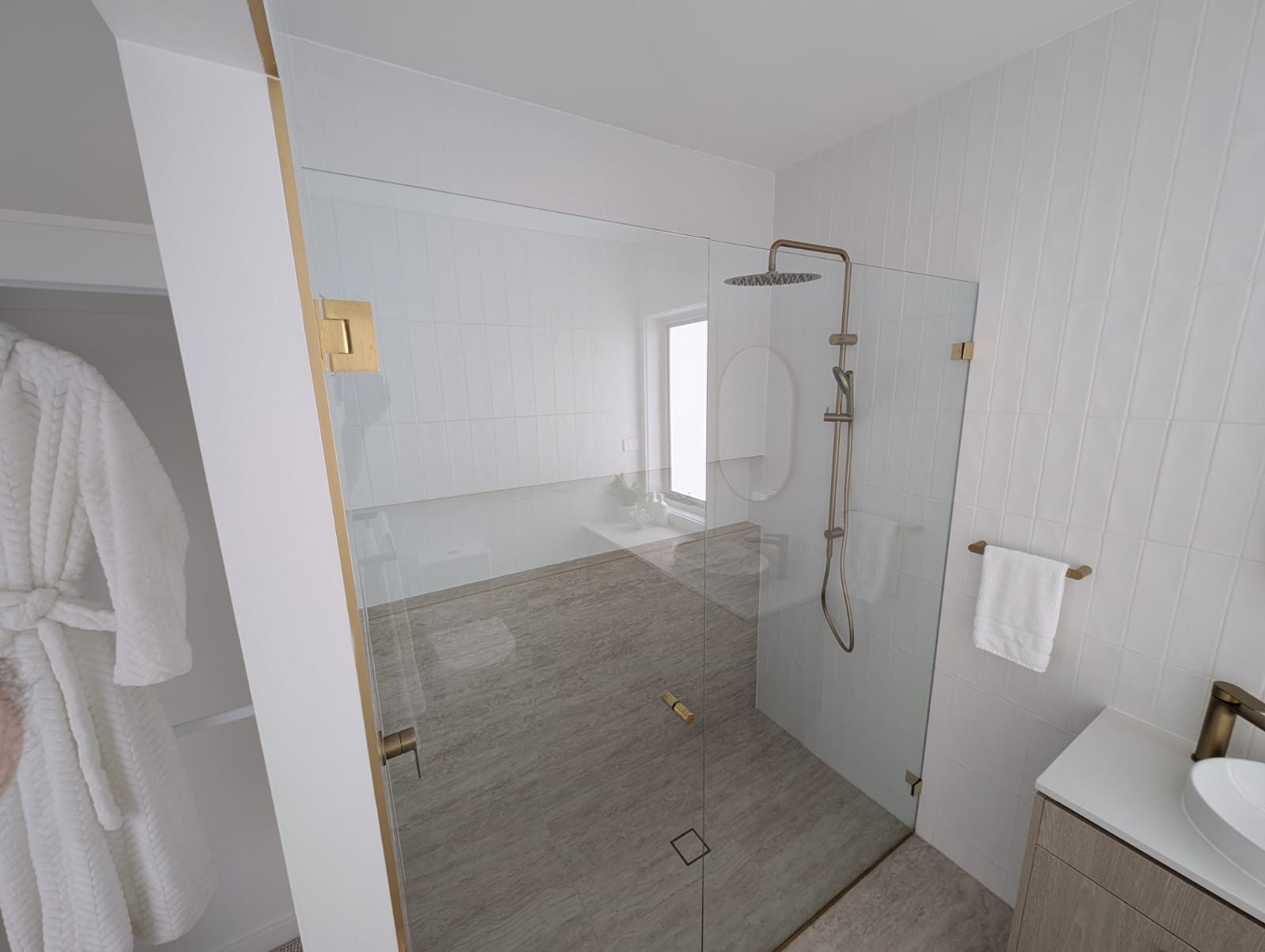 Frameless walk-in shower screen with brushed brass hardware