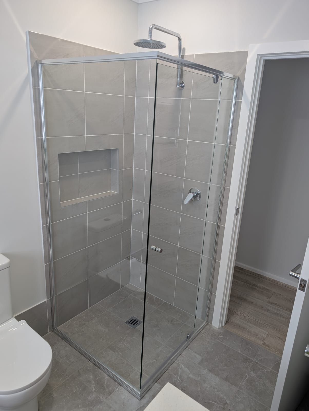 Semi-frameless shower screen with silver frame and frameless pivot door